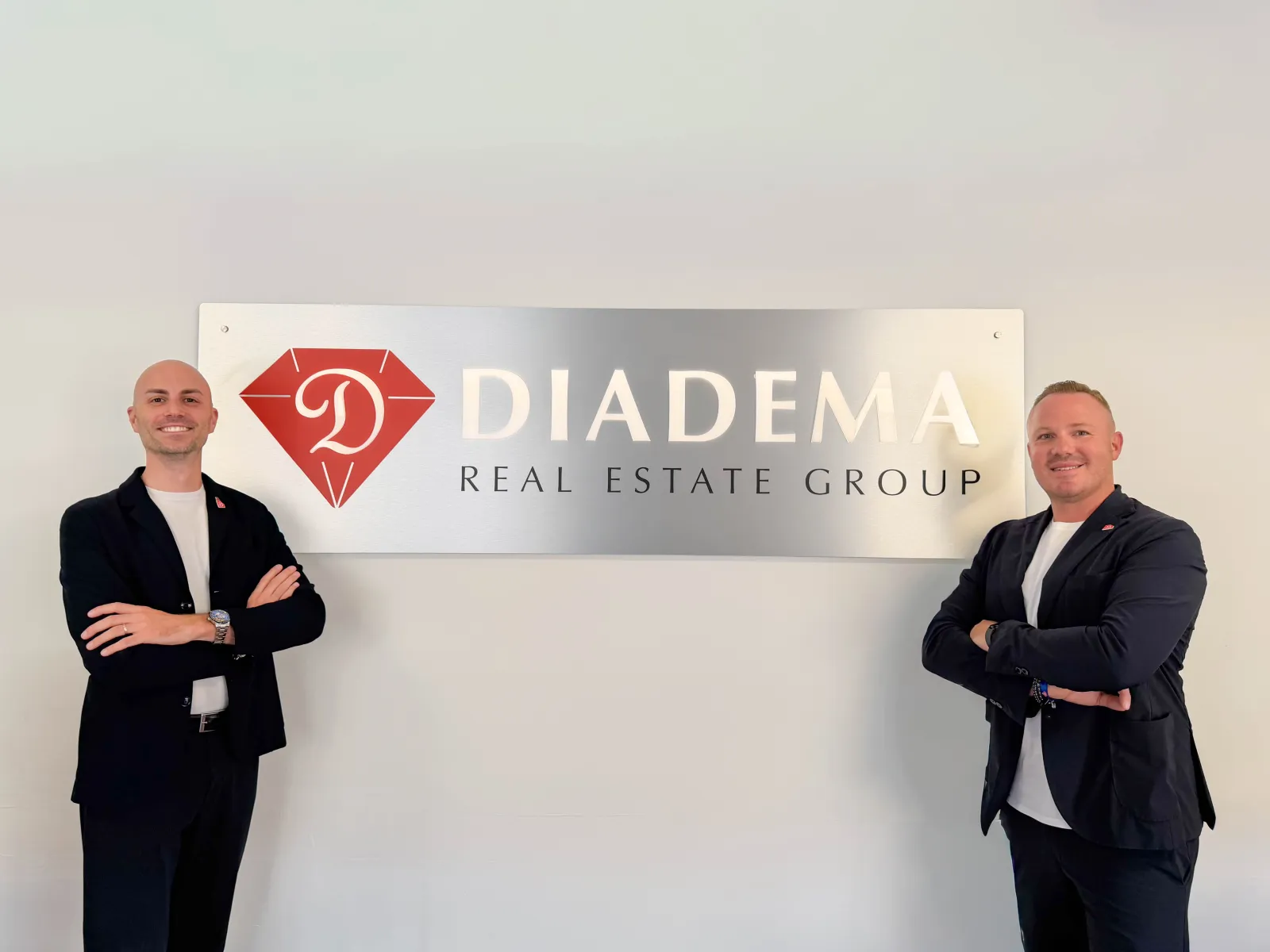 I titolari di Diadema RE Group davanti al logo dell'agenzia